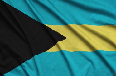 Bahamas flag is depicted on a sports cloth fabric with many folds. Sport team waving banner