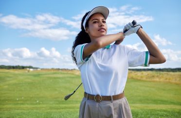 Black woman playing golf on field