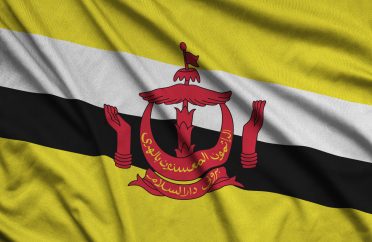 Brunei Darussalam flag is depicted on a sports cloth fabric with many folds