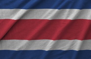 Costa Rica flag depicted on folded wavy fabric of old cloth