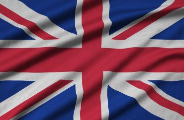 Great britain flag is depicted on a sports cloth fabric with many folds. Sport team waving banner