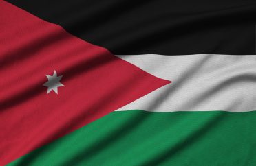 Jordan flag is depicted on a sports cloth fabric with many folds. Sport team waving banner