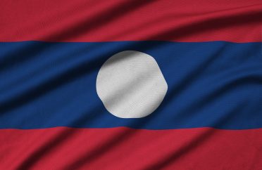 Laos flag is depicted on a sports cloth fabric with many folds. Sport team waving banner