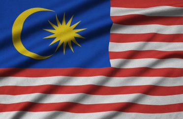 Malaysia flag is depicted on a sports cloth fabric with many folds. Sport team waving banner