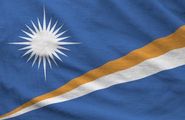 Marshall Islands flag depicted on folded wavy fabric of old cloth