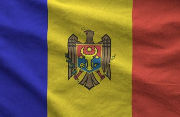 Moldova flag depicted on folded wavy fabric of old cloth