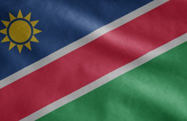 Namibian flag waving in the wind. Close up of Namibia banner blowing soft silk.