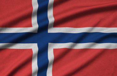 Norway flag is depicted on a sports cloth fabric with many folds. Sport team waving banner