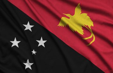 Papua New Guinea flag is depicted on a sports cloth fabric with many folds