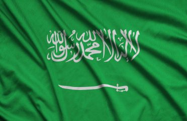 Saudi Arabia flag is depicted on a sports cloth fabric with many folds. Sport team waving banner