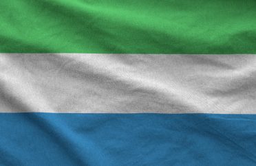 Sierra Leone flag depicted on folded wavy fabric of old cloth