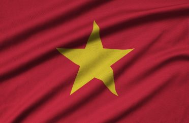 Vietnam flag is depicted on a sports cloth fabric with many folds. Sport team waving banner